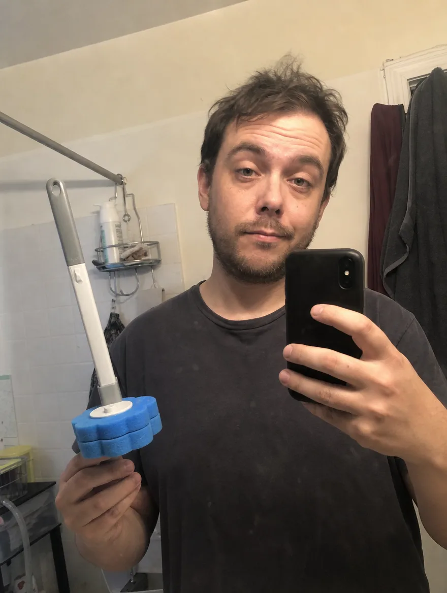 Man taking a mirror selfie holding the TossClean wand